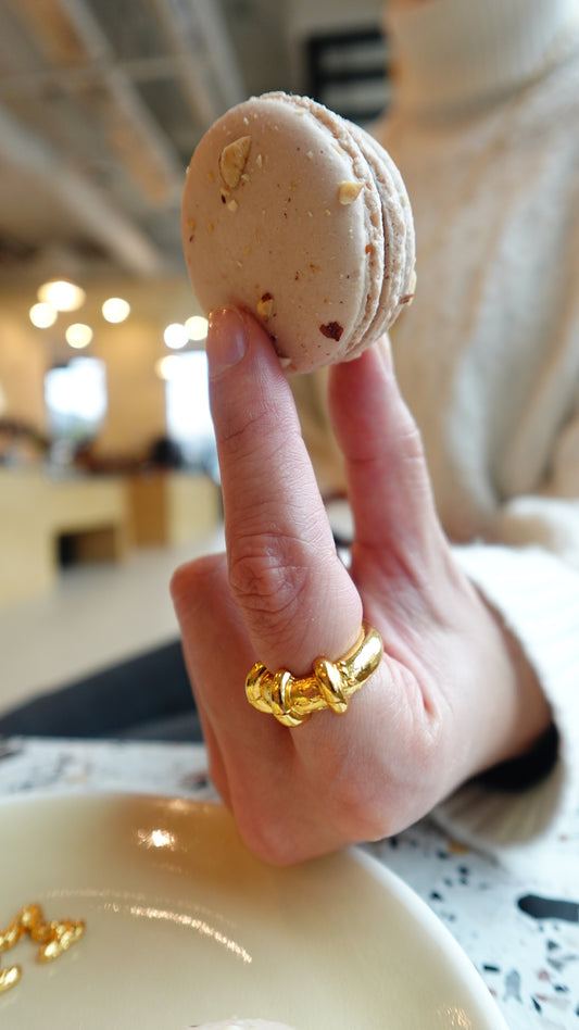 creative jewelry photos, a girl grabbing a macaron with a gold chunky ring