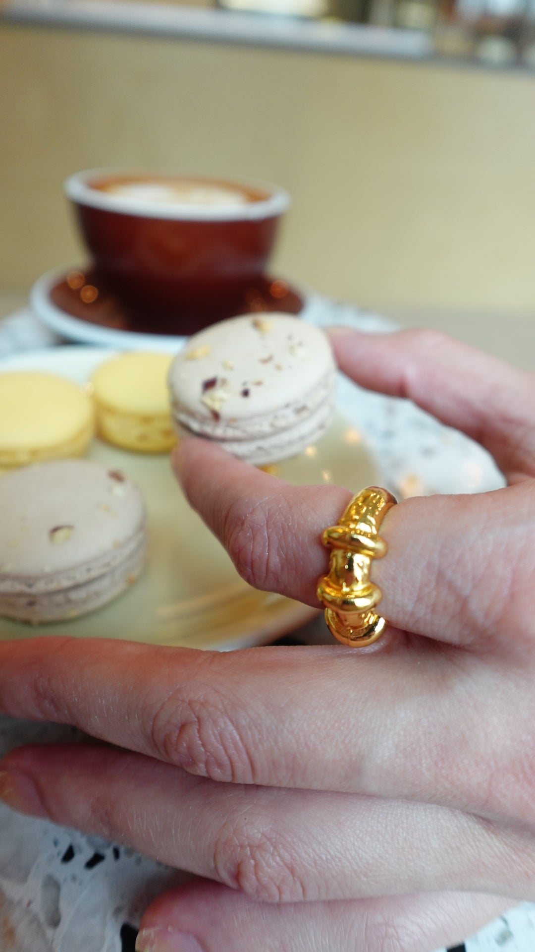 an aesthetic cafe, macarons and a gold chunky ring
